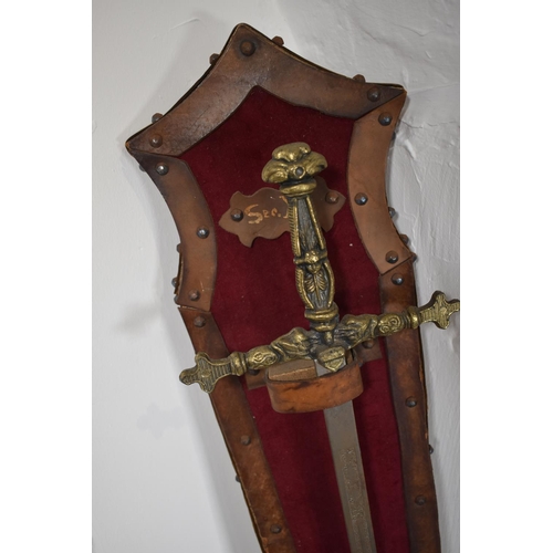 107 - Vintage sword with brass hilt. Etched decoration on the blade. Mounted on a leather and velvet cover... 