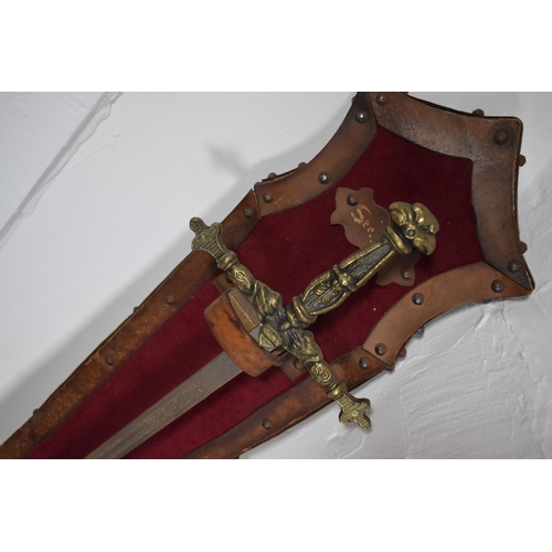 107 - Vintage sword with brass hilt. Etched decoration on the blade. Mounted on a leather and velvet cover... 