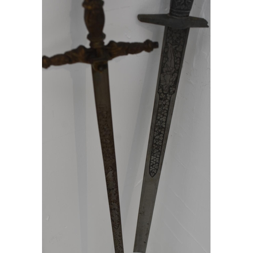 130 - Two swords with decorated blades. Both with damaged hilts. Largest measures 102cm long