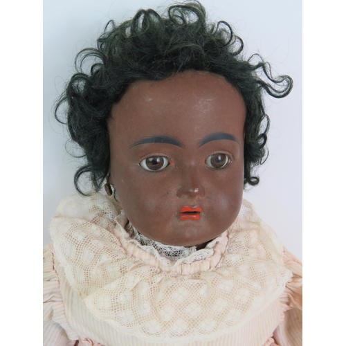 122 - An early 20th Century Bisque headed black girl doll with glass eyes and jointed arms and legs. Fully... 