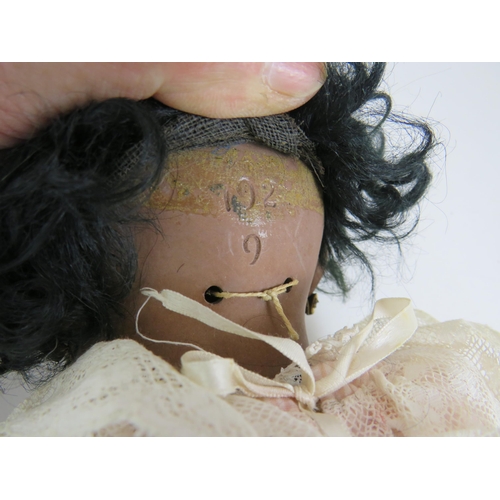 122 - An early 20th Century Bisque headed black girl doll with glass eyes and jointed arms and legs. Fully... 