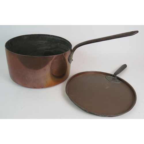 145 - Various copper and brass ware including candlesticks, a huge 19th Century sauce pans, trio of frying... 