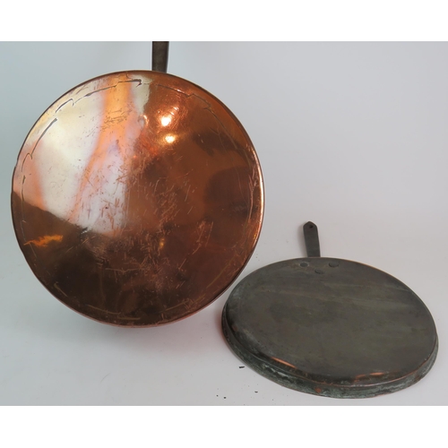 145 - Various copper and brass ware including candlesticks, a huge 19th Century sauce pans, trio of frying... 