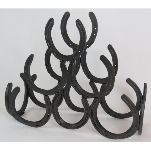 224 - A blacksmith made horseshoe six bottle wine rack made from real horseshoes. Height 36cm, width 45cm.... 