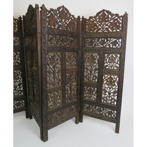 37 - A carved hardwood Indo-Persian table screen of four sections each with carved panels depicting vines... 