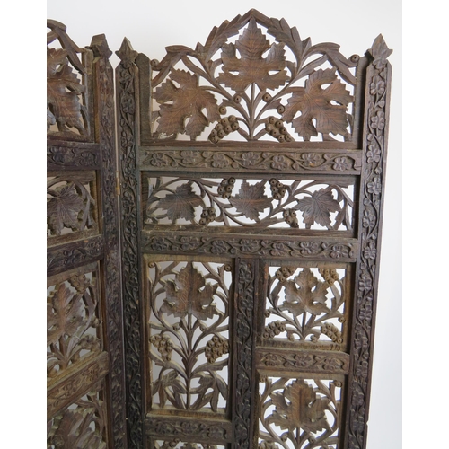 37 - A carved hardwood Indo-Persian table screen of four sections each with carved panels depicting vines... 