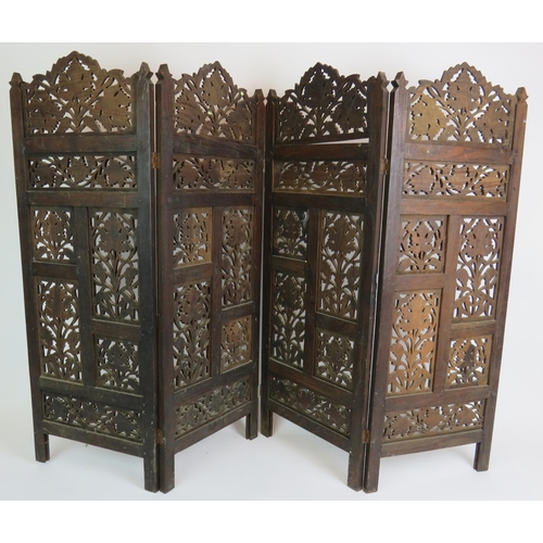 37 - A carved hardwood Indo-Persian table screen of four sections each with carved panels depicting vines... 