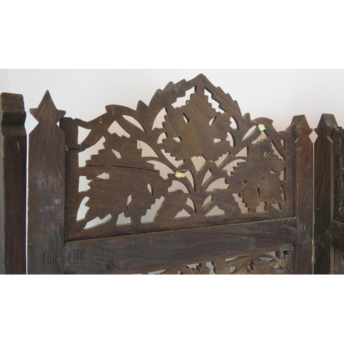 37 - A carved hardwood Indo-Persian table screen of four sections each with carved panels depicting vines... 