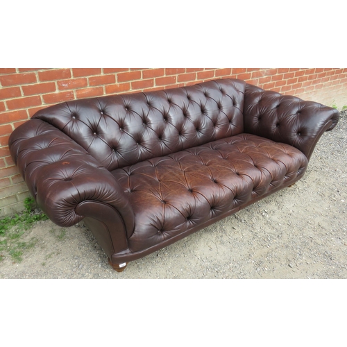 704 - A large antique style Chesterfield sofa upholstered in distressed chocolate brown buttoned leather, ... 