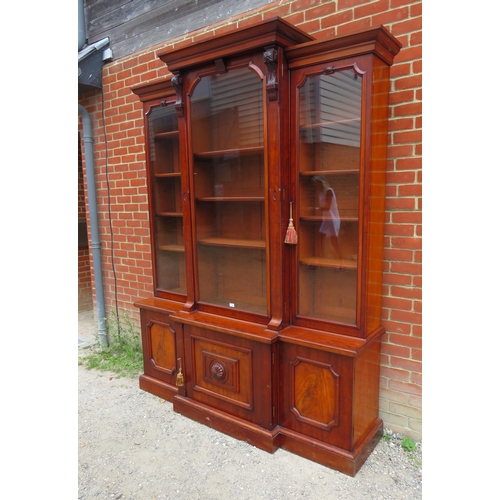 705 - A Victorian mahogany breakfront library bookcase, the cornice featuring carved corbels, over three g... 