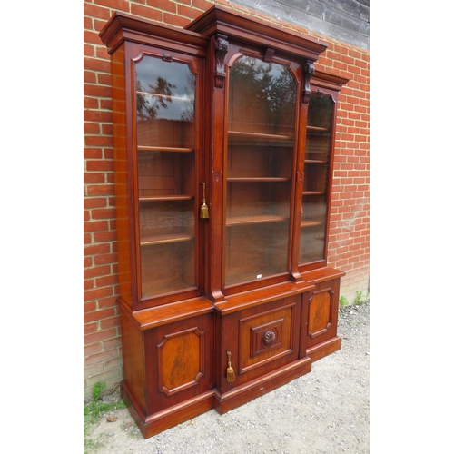 705 - A Victorian mahogany breakfront library bookcase, the cornice featuring carved corbels, over three g... 