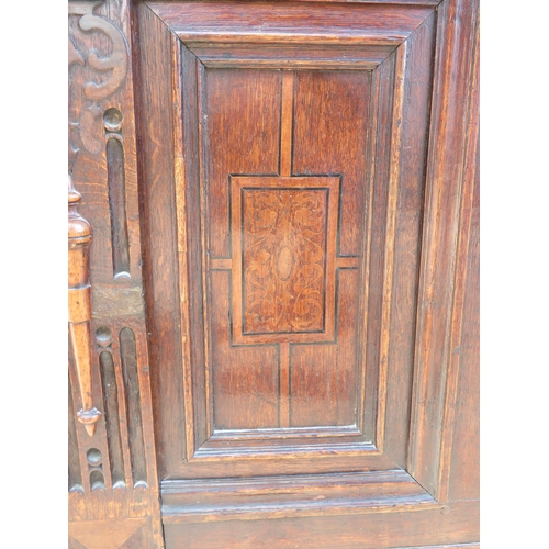 707 - An early 18th century oak coffer with twin candle boxes and marquetry inlaid fielded panels to front... 