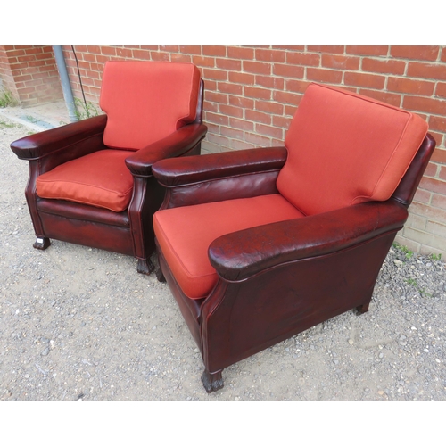 727 - A pair of Art Deco club armchairs upholstered in distressed brown leather with seat cushions finishe... 