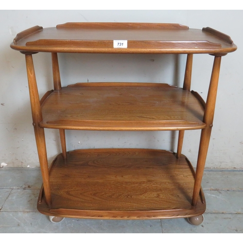 731 - A mid century Ercol Windsor three tier butler's/drinks trolley in elm, raised on castors.
78cm high ... 