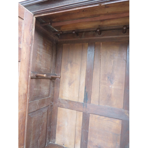 738 - An early 18th century oak wardrobe, the double doors with brass knobs & fielded panels, opening onto... 