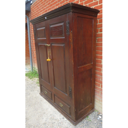 738 - An early 18th century oak wardrobe, the double doors with brass knobs & fielded panels, opening onto... 