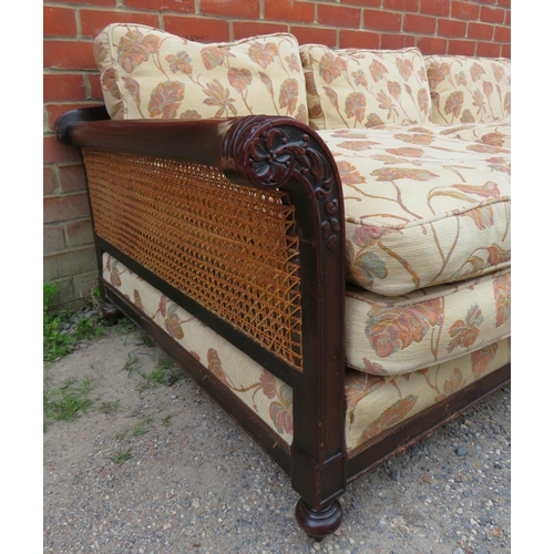 739 - A Victorian mahogany framed three seater bergere sofa with acanthus carved and scrolled armrests uph... 