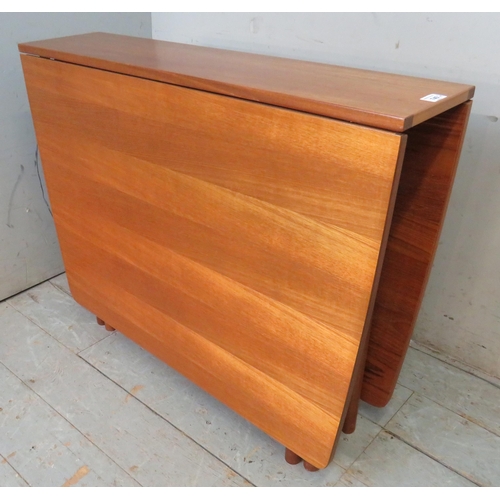 740 - A mid century teak drop leaf dining table by McIntosh raised on cylindrical supports, together with ... 