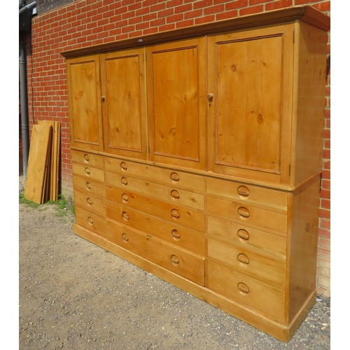 747 - A very large antique pine linen press, the top section with two pairs of double doors enclosing six ... 