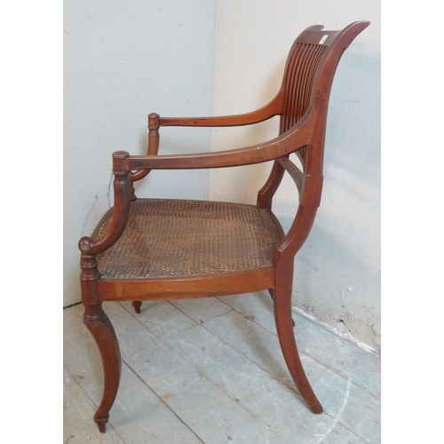 754 - An Edwardian Regency revival mahogany elbow chair with bergere seat, raised on sabre legs.
90cm high... 