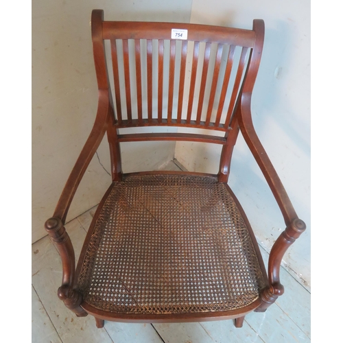 754 - An Edwardian Regency revival mahogany elbow chair with bergere seat, raised on sabre legs.
90cm high... 