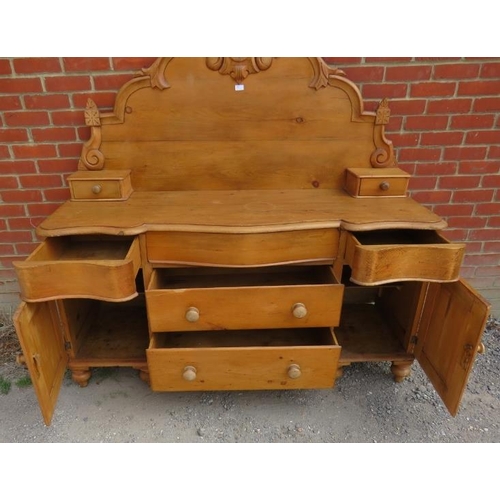 760 - An antique pine Lancashire dresser, the shaped back decorated with carved cornice & finials, over a ... 