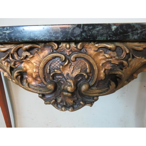 769 - A vintage black marble topped console table in the French taste, with ornately mould gesso frieze, r... 