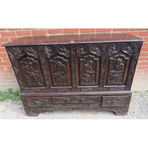 772 - A 19th century oak vestry chest ornately carved with ecclesiastical motifs, with three base drawers ... 