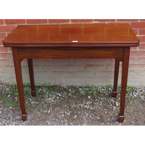 775 - An Edwardian mahogany turnover tea table with round corners, raised on tapering square supports, ter... 