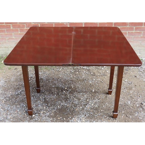 775 - An Edwardian mahogany turnover tea table with round corners, raised on tapering square supports, ter... 