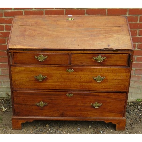 785 - A George III mahogany and oak bureau, the fall front enclosing an array of small drawers and cubby h... 