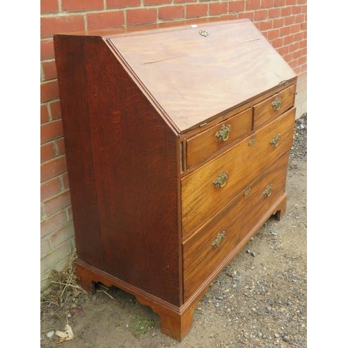 785 - A George III mahogany and oak bureau, the fall front enclosing an array of small drawers and cubby h... 