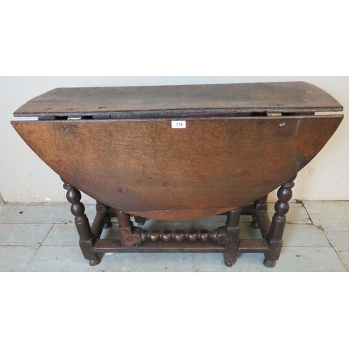 790 - A late 17th century oak gate leg table, raised on a ball turned base, united by lower stretchers ter... 