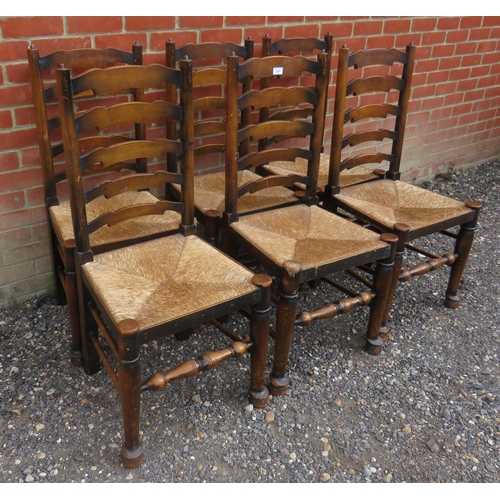 797 - A set of six vintage oak framed ladder back dining chairs with rush seats, raised on tapering suppor... 