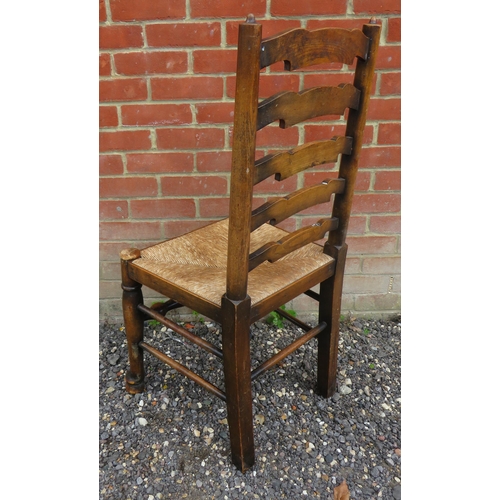 797 - A set of six vintage oak framed ladder back dining chairs with rush seats, raised on tapering suppor... 