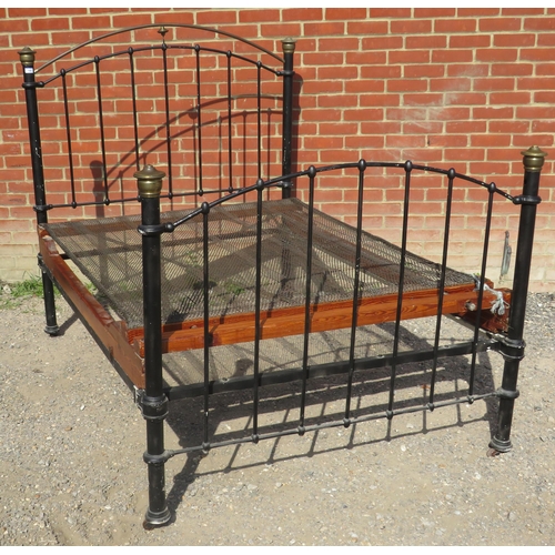 799 - A Victorian wrought iron & brass double bed painted black with pressed brass finials. Complete with ... 