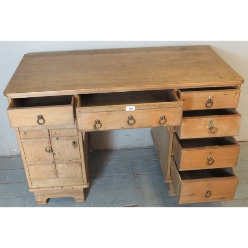 808 - An antique pine kneehole desk, the base having an arrange of six drawers and a cupboard to one side ... 