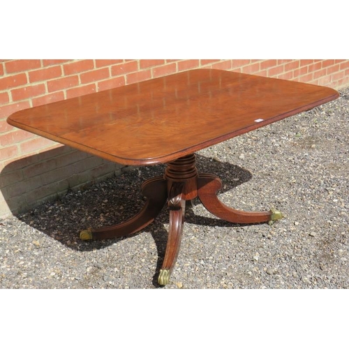 810 - A Regency mahogany rectangular tilt top breakfast table, with a turned pedestal raised on four sabre... 