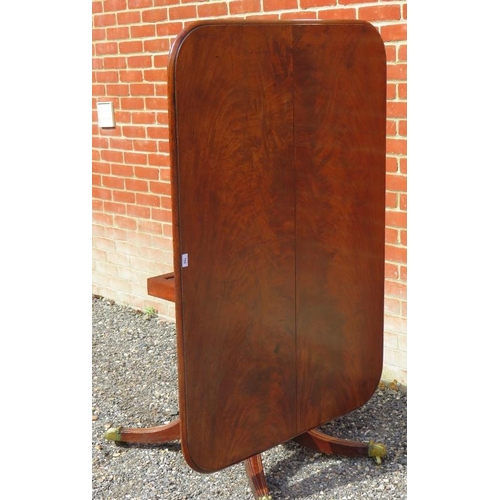 810 - A Regency mahogany rectangular tilt top breakfast table, with a turned pedestal raised on four sabre... 