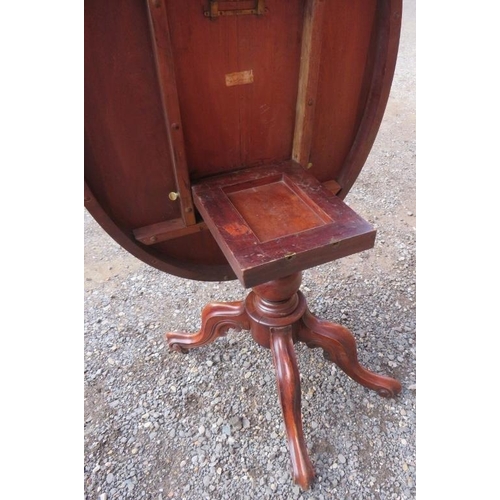 822 - A 19th century Victorian mahogany tilt top oval loo table on a turned column base raised on four Fle... 