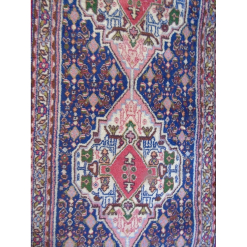 904 - An early-mid 20th Century Persian runner with fine inked motifs to cater and surrounded by a flowere... 