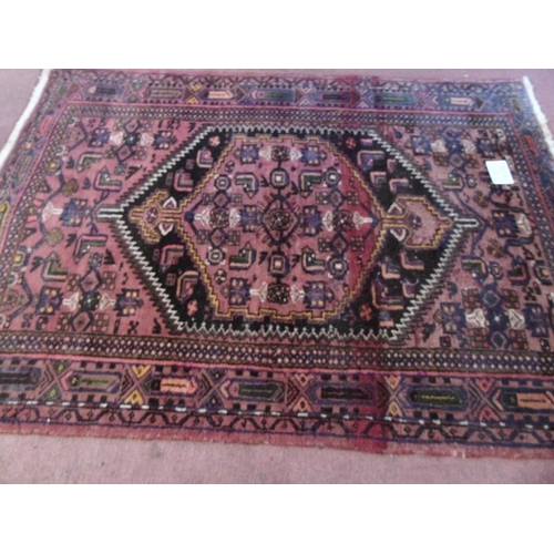 905 - An early-mid 20th Century Persian rug with central cartouche on red ground. 200cm x 140cm approx.
Co... 