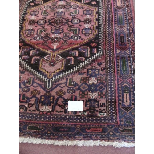 905 - An early-mid 20th Century Persian rug with central cartouche on red ground. 200cm x 140cm approx.
Co... 