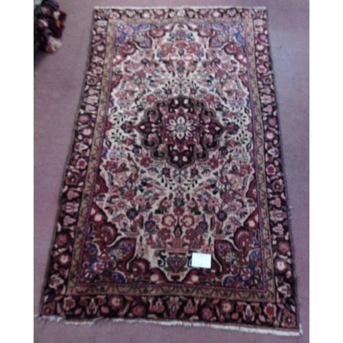 909 - An early - mid 20th Century Persian rug with central design flanked by a deep flower border. 232cm x... 