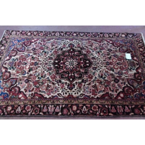 909 - An early - mid 20th Century Persian rug with central design flanked by a deep flower border. 232cm x... 