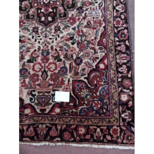 909 - An early - mid 20th Century Persian rug with central design flanked by a deep flower border. 232cm x... 