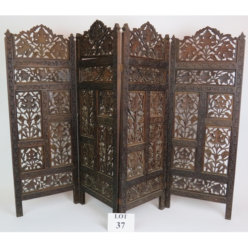 37 - A carved hardwood Indo-Persian table screen of four sections each with carved panels depicting vines... 