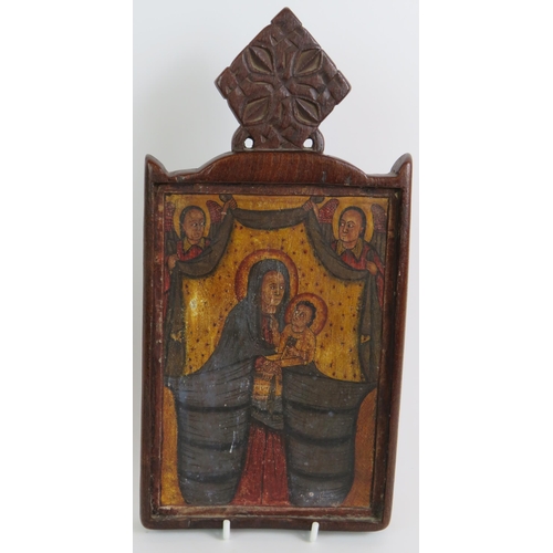 63 - A two part carved hardwood Ethiopian Christian icon depicting St George on one panel and the Madonna... 