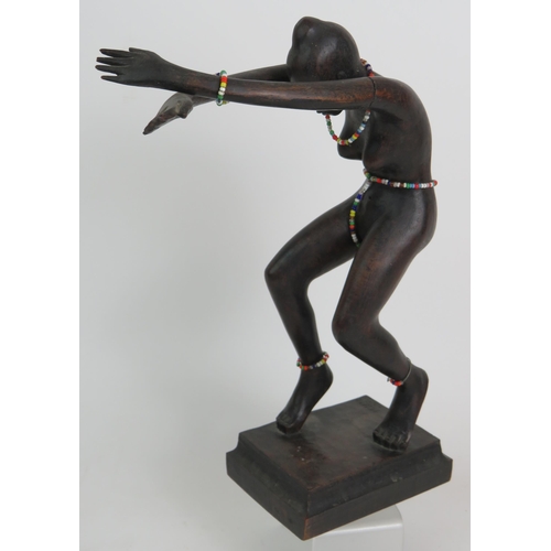 74 - A Brazilian Art Deco carved hardwood sculpture of a naked female tribal dancer with beaded adornment... 