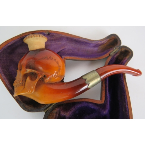 87 - A 19th Century carved Meerschaum cheroot pipe holder carved in the form of a human skull, amber mout... 